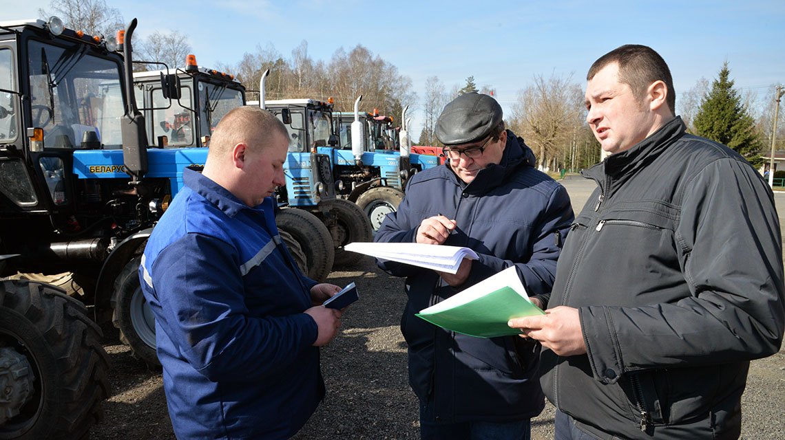 Дмитрий ГРУК и Валентин ПОПЕСКУ (справа налево) убедились: Валерий БАЗЮК – работник дисциплинированный, документы у механизатора в полном порядке. 